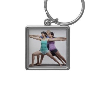 2 women and 1 man doing a standing yoga pose keychain