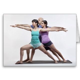 2 women and 1 man doing a standing yoga pose greeting card